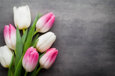 Çiçekler beyaz ve pembe; gri arkaplanda.