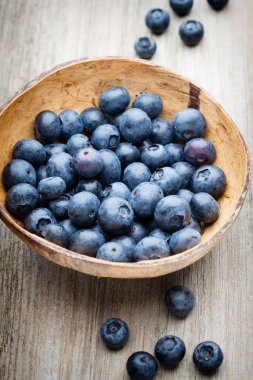 Tahta bir masada kasede yaban mersini..