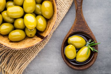 Taze zeytin ve gri arka plan. Kase ve kaşıkta zeytin.