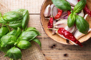 Ahşap arka planda taze fesleğen. Kasede sarımsak karışımı..