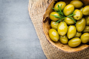 Taze zeytin ve gri arka plan. Kase ve kaşıkta zeytin.