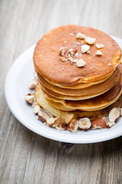 Ahşap arka planda ballı ev yapımı krep yığını.