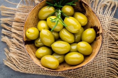 Taze zeytin ve gri arka plan. Kase ve kaşıkta zeytin.