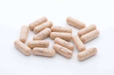 Beyaz arkaplanda Ginkgo biloba kapsülü.