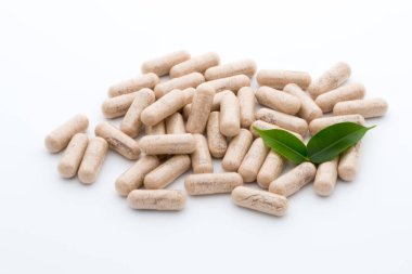 Beyaz arkaplanda Ginkgo biloba kapsülü.