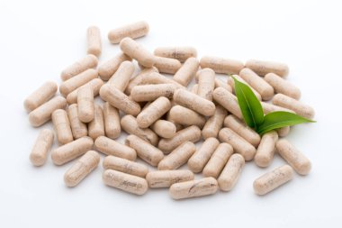 Beyaz arkaplanda Ginkgo biloba kapsülü.