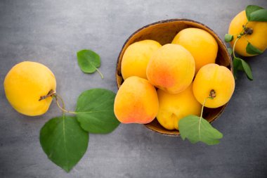 Ahşap arka planda yaprakları olan kayısı.