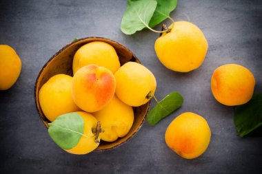 Köy arka planında ahşap kasede taze kayısılar..