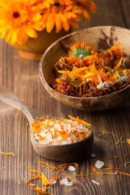 Homeopatik ilaç, calendula kuru çiçekler ve tahta yüzey.