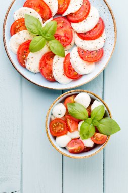 Domates, mozzarella peyniri, fesleğen ve baharatlar gri tahtada. İtalyan geleneksel Caprese salata malzemeleri. Akdeniz yemekleri.