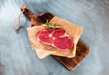 Tahta kesme tahtasının üzerinde taze pirzola, ıspanak, mercimek ve rustik tarzda tespih..