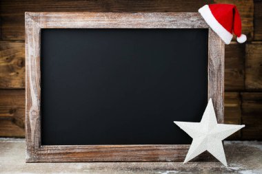 Süslü Noel tahtası. Noel Baba şapkası, yıldızlar, tahta arka plan. Klasik Rustik Biçim.