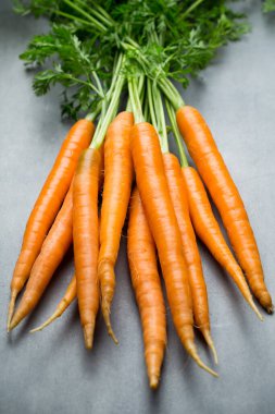 Gri arka planda taze havuçlar.