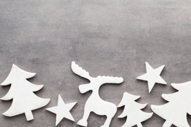 Noel arkaplanı. Gri arka planda beyaz ağaç süslemeleri. Geyik. Ladin. Yıldız. Melek.