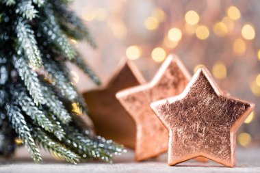 Bronz Noel yıldızı süslemesi. Bokeh arka planında bronz bayram dekorasyonları.