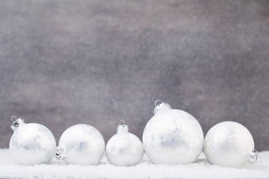 Parlak arka planda gümüş Noel topları.