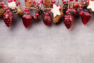 Kırmızı toplu ve gri arkaplanlı Noel çelengi.