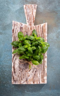 Kırsal ahşap arka planda kesilmiş taze organik fesleğen.