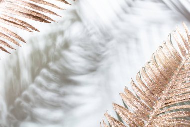 Mavi duvarda altın palmiye yaprakları ve gölgeler.