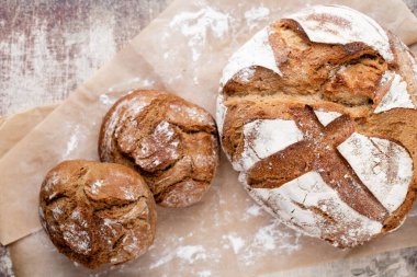 Koyu gri mutfak masasında taze pişmiş ekmek..