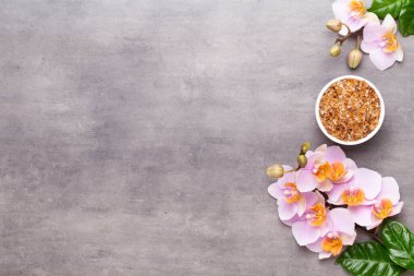 Spa aromaterapi arka planı, basit orkide çiçekleriyle süslenmiş çeşitli güzellik ürünleri..