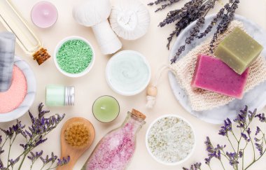 Spa ve banyo ev yapımı kozmetik ürünleri. Pastel arka planda kaplıca ürünleri olan şişeler, üst görünüm.. 