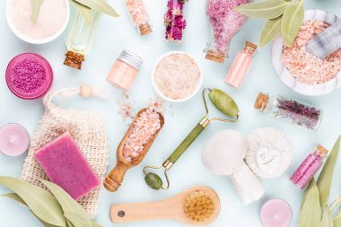 Kaplıca ve ev yapımı kozmetik ürünleri. Pastel arka planda kaplıca ürünleri olan şişeler.