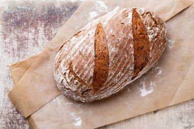 Koyu gri mutfak masasında taze pişmiş ekmek..