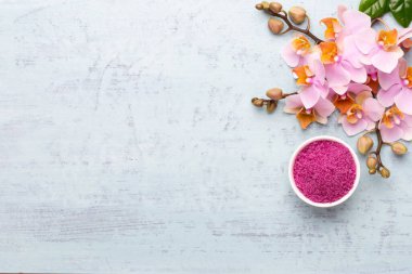 Spa aromaterapi arka planı, basit orkide çiçekleriyle süslenmiş çeşitli güzellik ürünleri..