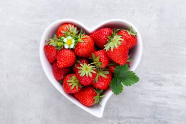 Çilekli kalp. Beyaz ahşap masadaki taze çilekler. Üst görünüm, alanı kopyala. 
