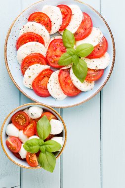 Domates, mozzarella peyniri, fesleğen ve baharatlar gri tahtada. İtalyan geleneksel Caprese salata malzemeleri. Akdeniz yemekleri.