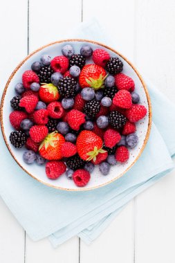 Ahşap arka planda bir tabakta taze meyve salatası. Düz konum, üst görünüm, kopyalama alanı.