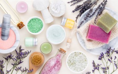 Spa ve banyo ev yapımı kozmetik ürünleri. Pastel arka planda kaplıca ürünleri olan şişeler, üst görünüm.. 