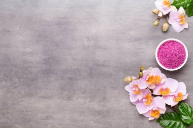 Spa aromaterapi arka planı, basit orkide çiçekleriyle süslenmiş çeşitli güzellik ürünleri..