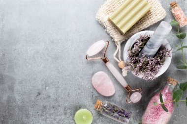 Kaplıca ve ev yapımı kozmetik ürünleri. Pastel arka planda kaplıca ürünleri olan şişeler.