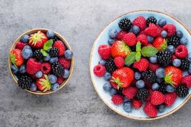 Ahşap arka planda bir tabakta taze meyve salatası. Düz konum, üst görünüm, kopyalama alanı.