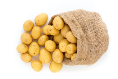 Ahşap arka planda taze çiğ patates çuvalı.