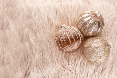 Altın noel sade topları yün arka planda.