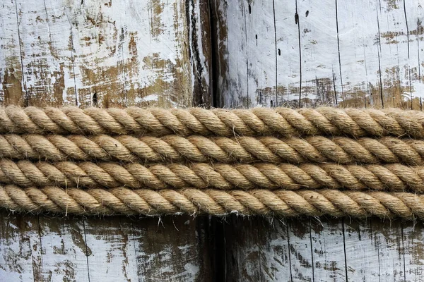 Vier lagen touw rond een houten stam gebonden, in de schaduw op een zonnige dag — Stockfoto