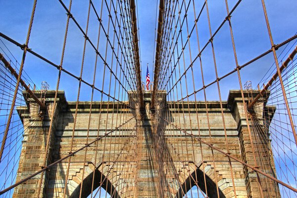 Close up view of Brooklyn Bridge arches with US flag