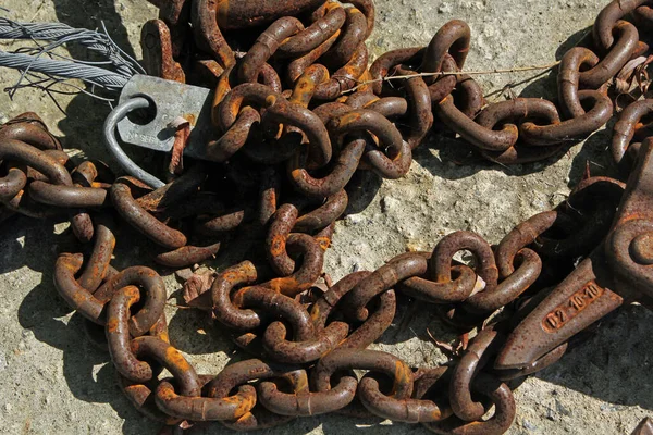 Starý rezavý železný řetěz s hákem leží na hrubém povrchu — Stock fotografie
