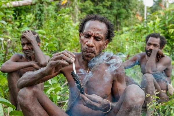  Korowai kabilesinden adam sigara içiyor