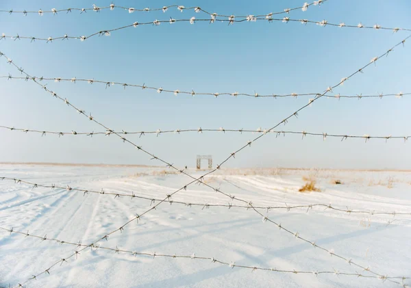 Filo spinato sullo sfondo del paesaggio innevato — Foto Stock