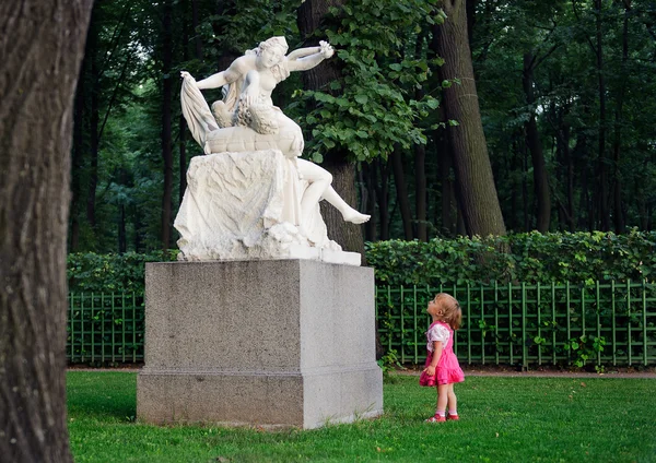 Little girl and  sculpture — Stock Photo, Image