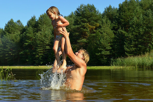 In the summer, bright sunny day, the little girl and man is bathed 