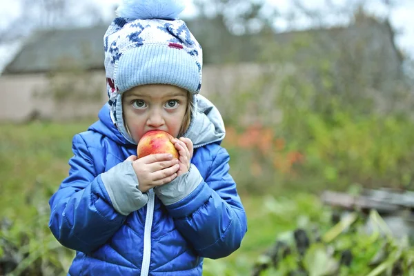 Das kleine Mädchen isst roten Apfel — Stockfoto