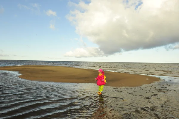 Kleines Mädchen an einem Herbststrand. — Stockfoto