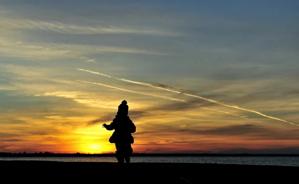 Silhouette ragazza tramonto bambino giocare mare — Foto Stock