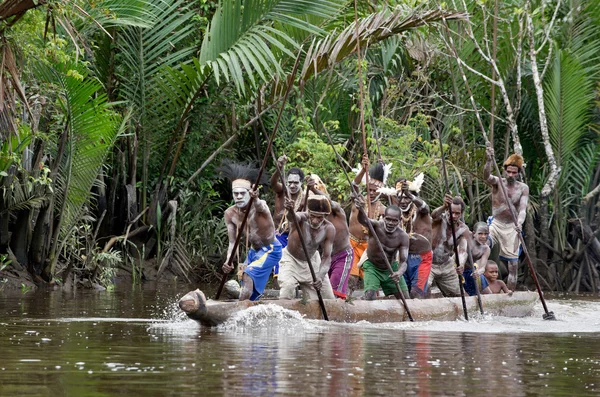 Asmat homens remando em sua canoa dugout — Fotografia de Stock