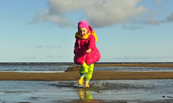 Little girl  on a sunset sandy autumn beach. — Stock Photo, Image